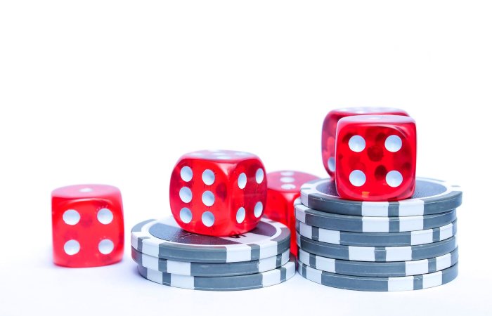 Vibrant red dice stacked with poker chips, ideal for gambling themes.
