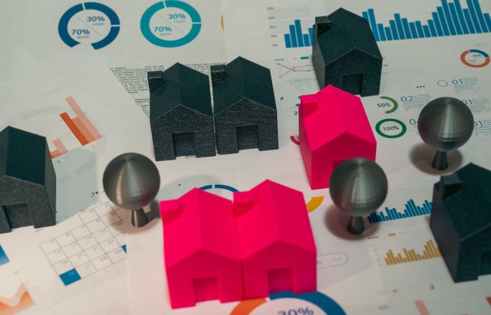 Abstract representation of real estate market analysis with model houses and charts.