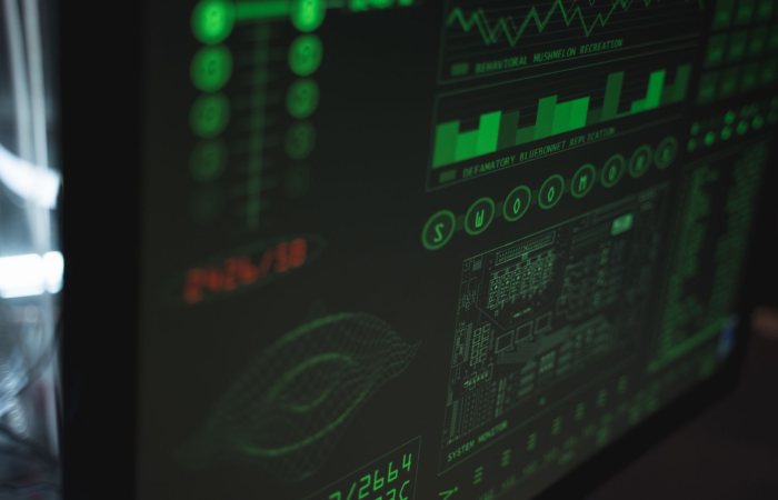 Close-up view of a computer displaying cybersecurity and data protection interfaces in green tones.