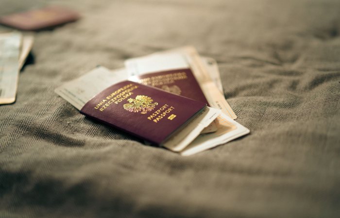 A close-up of a Polish passport and travel documents placed on a fabric surface, symbolizing travel and identity.