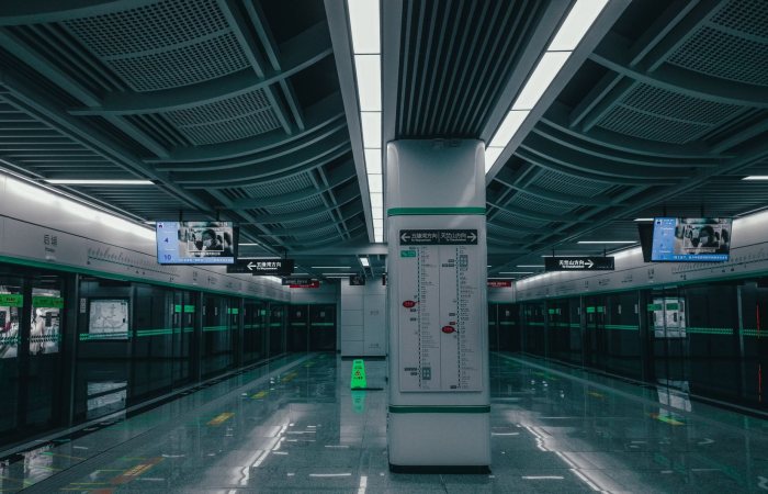 Empty modern subway platform with sleek design and digital signage at night.