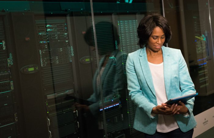 Female IT professional examining data servers in a modern data center setting.